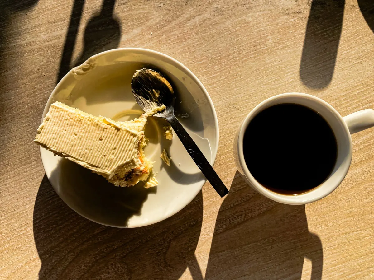Coffee and cake on a sunlit table