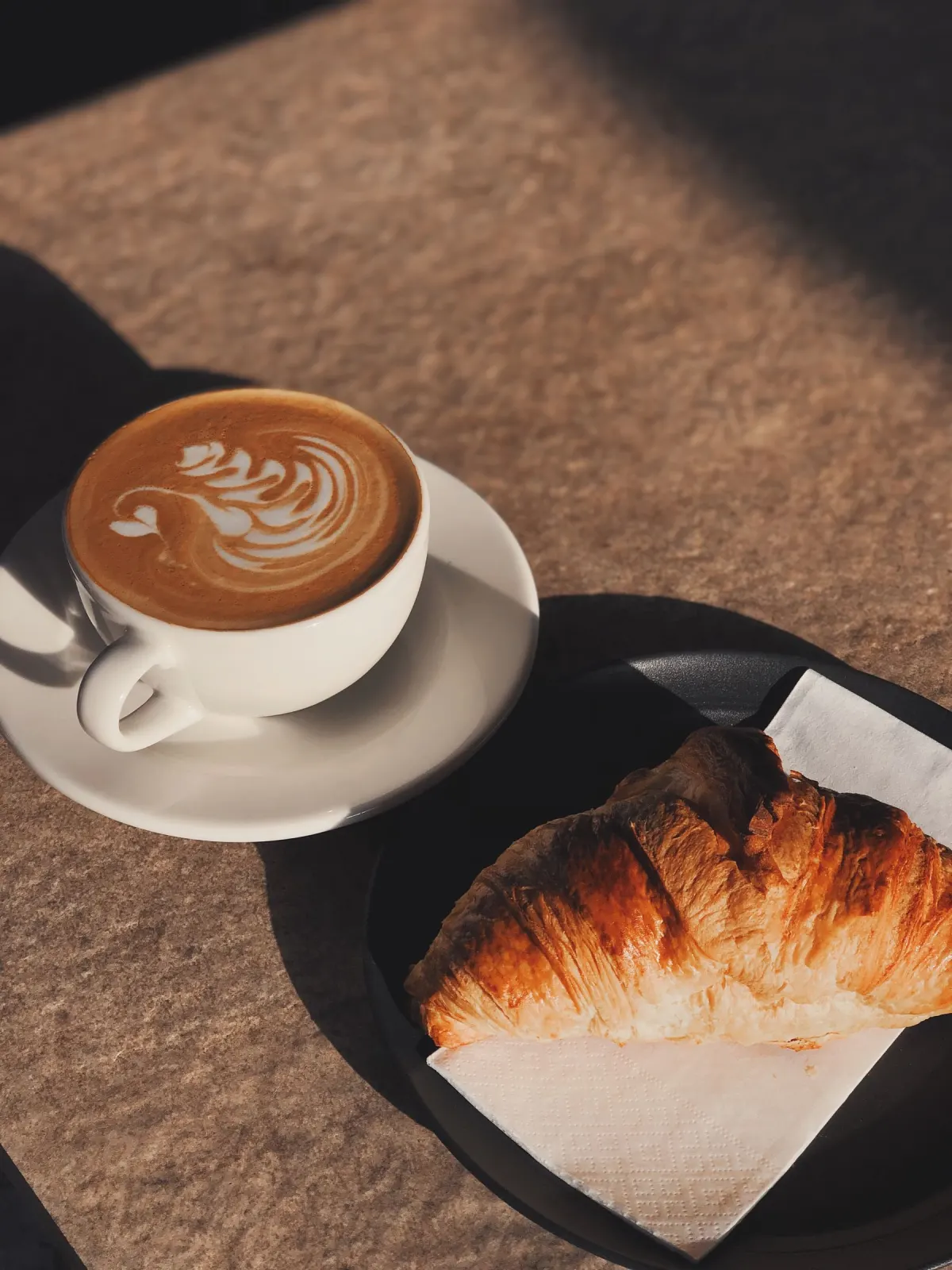 Latte art with a freshly baked pastry
